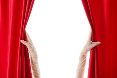 Beyaz arka planda kırmızı kadife perdeleri açan kadın elleri