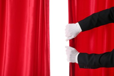 Sihirbazın elleri beyaz arkaplanda kırmızı kadife perdeleri açıyor