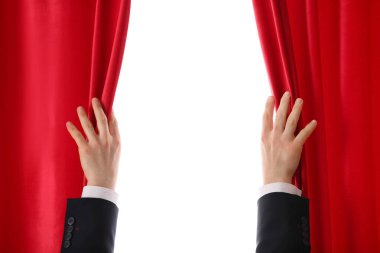 Sihirbazın elleri beyaz arkaplanda kırmızı kadife perdeleri açıyor