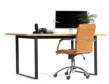 Beyaz arka planda modern bilgisayar ve ev bitkisine sahip şık çalışma alanı