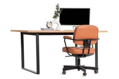 Beyaz arka planda modern bilgisayar ve ev bitkisine sahip şık çalışma alanı