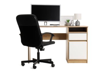 Beyaz arka planda modern bilgisayar, lamba ve ev bitkisine sahip şık çalışma alanı