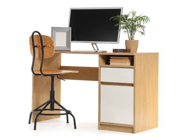 Beyaz arka planda modern bilgisayar ve ev bitkisine sahip şık çalışma alanı