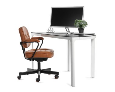 Beyaz arkaplanda bilgisayar, dizüstü bilgisayar ve ev bitkisi bulunan şık çalışma alanı