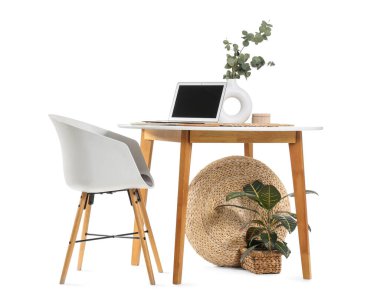 Modern dizüstü bilgisayarlı şık masa ve beyaz arka planda izole edilmiş ev bitkileri