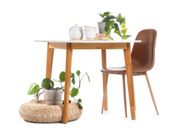 Beyaz arka planda izole edilmiş ev bitkileri, çaydanlık ve fincanları olan şık masa