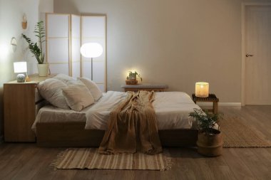 Şık bir yatak odası, rahat bir yatak odası, katlanan perdeler ve akşamları parlayan lambalar