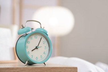 Yatak odasındaki komodinin üzerindeki çalar saat, yakın plan.