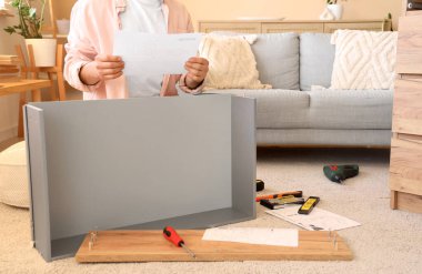 Talimatları olan bir adam çekmeceleri evde topluyor.