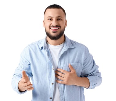 Minnettar genç adam göğüs göğse bastırıyor ve beyaz arka planda gülümsüyor.