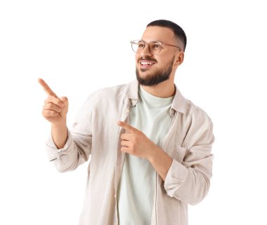 Gözlüklü yakışıklı genç adam beyaz arka planda bir şeye bakıyor.