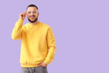 Leylak arkaplanda gözlüklü yakışıklı bir genç.