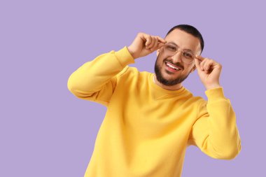 Leylak arkaplanda gözlüklü yakışıklı bir genç.