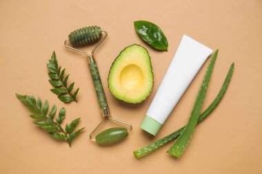 Doğal kozmetik ürünü, malzemeler ve renk arkaplan üzerine yüz masajı aracı ile kompozisyon