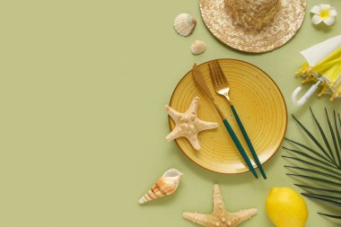 Çatal bıçak, şapka, tropikal yaprak ve yeşil arka planda deniz kabukları olan güzel bir masa.