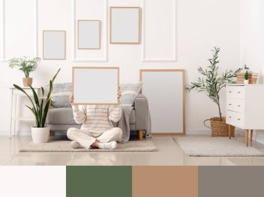 Çerçeveli genç bir kadın modern oturma odasında yerde oturuyor. Farklı renk desenleri