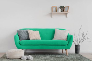 Işık duvarının yanındaki yeşil kanepeli oturma odasının içinde.