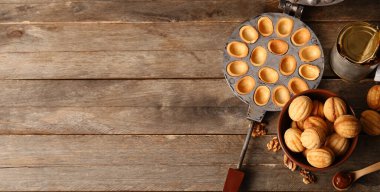 Lezzetli ceviz şekilli kurabiyeler, kaynamış süt ve ahşap zemin üzerinde pişirme formu.