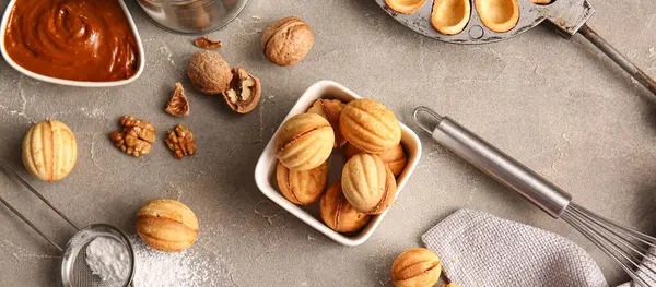 Lezzetli ceviz şekilli kurabiyeler ve grunge arkaplanındaki malzemelerle kompozisyon