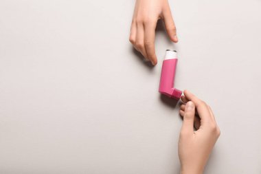 Beyaz arka planda astım spreyli çocuk elleri