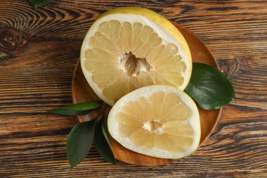 Kesilmiş taze meyve ve ahşap arka planda yapraklar.