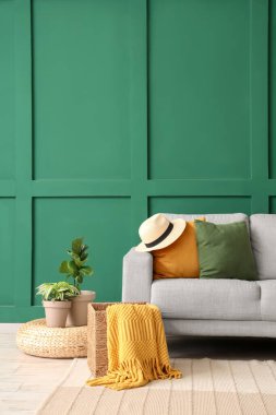 Gri kanepe, sepet ve puf ile şık bir oturma odası.