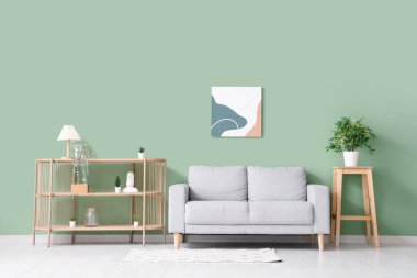 Oturma odasının iç dekorasyonu yumuşak kanepe ve renkli duvarın yanındaki raf ünitesi.