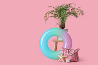 Şişirilebilir halka, pembe arka planda bitki ve torba