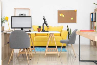 Moda ofisinde bilgisayar monitörleri olan modern işyeri