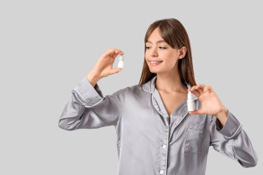 Işık arka planında göz damlası olan genç bir kız.