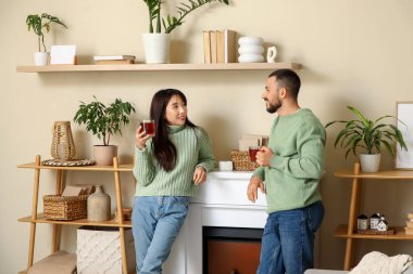 Evlerinde şöminenin yanında çay içen mutlu çifti severler.