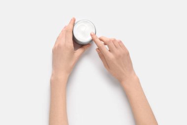 Beyaz arka planda kozmetik krem kavanozu olan güzel kadın elleri