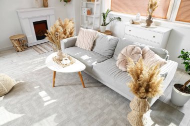 Rahat gri kanepesi, sehpası ve otları olan şık bir oturma odası.