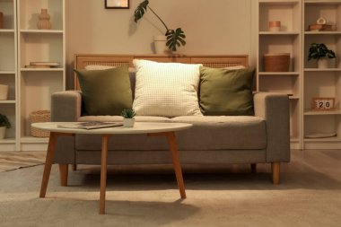 Gri kanepesi ve kahve masası olan şık bir oturma odası.