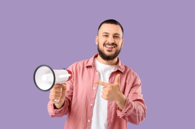 Leylak arka planında megafona işaret eden yakışıklı genç adam.