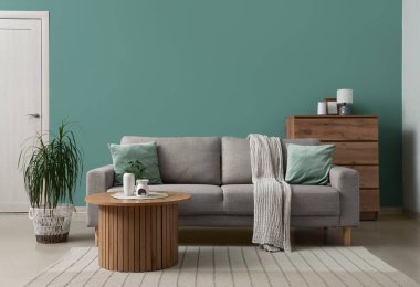 Gri kanepesi, ahşap masası ve tuvaleti olan şık bir oturma odası.