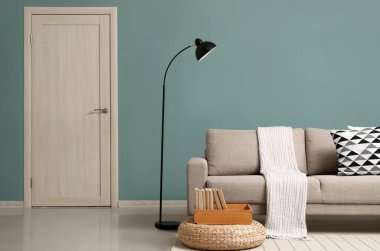 Gri kanepesi, lambası ve puf olan şık bir oturma odası.