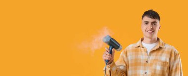 Sarı arka planda giysi için buharlı genç bir adam ve metin için yeri var.