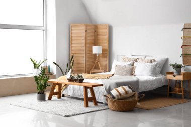 Yatağı, çiçekleri ve çiçekleri olan hafif yatak odasının içi.