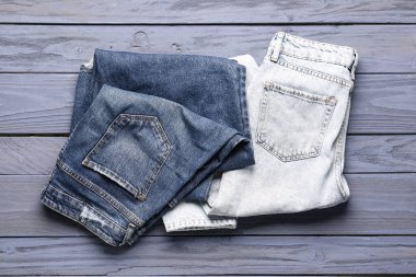 Mavi ahşap arka planda farklı bir kot pantolon.