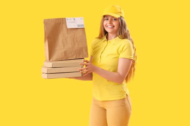 Kese kağıdı ve sarı arka planda pizza kutuları olan kadın kurye.