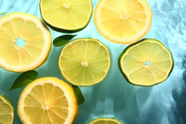Mavi zemin üzerinde taze limon ve limon dilimleri