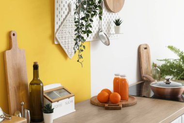 Mutfaktaki ahşap tezgahta meyve suyu şişeleri ve portakallarla tahta kesmek.