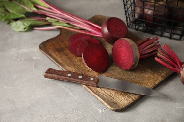 Taze pancar kökü ve gri masada bıçak ile kesme tahtası.