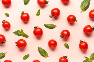 Taze vişneli domates ve pembe arka planda fesleğen.