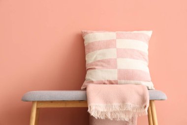 Yastıklı gri bank ve pembe duvarın yanında battaniye