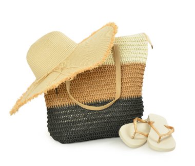 Hasır şapka, plaj çantası ve beyaz arka planda parmak arası terlikler.