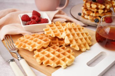 Beyaz arka planda akçaağaç şurubuyla lezzetli waffle tahtaları.