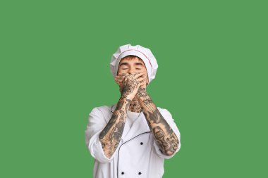 Yeşil arka planda gülen genç şef