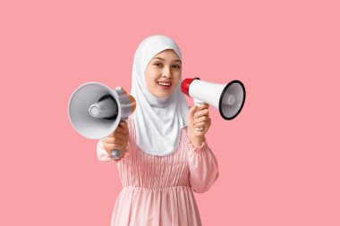 Pembe arka planda megafonları olan genç Asyalı Müslüman kadın. Ulusal Duyulma Günü